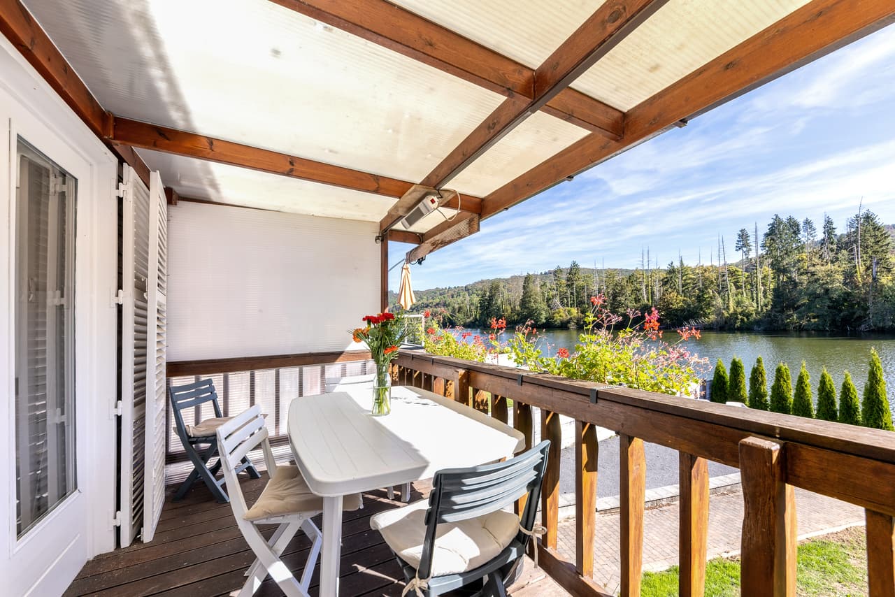 Overdekt terras met tafel en uitzicht op de rivier