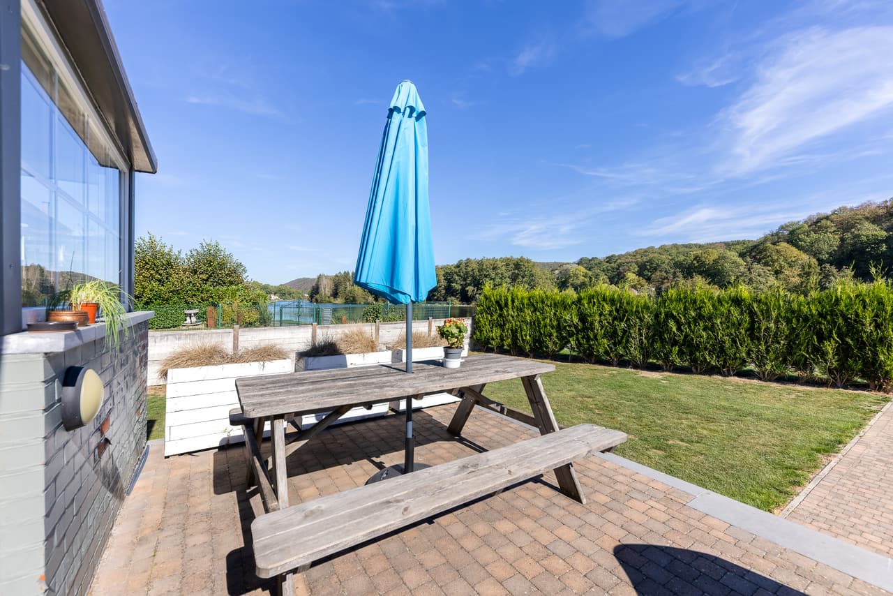 Terras met picknicktafel en blauwe parasol