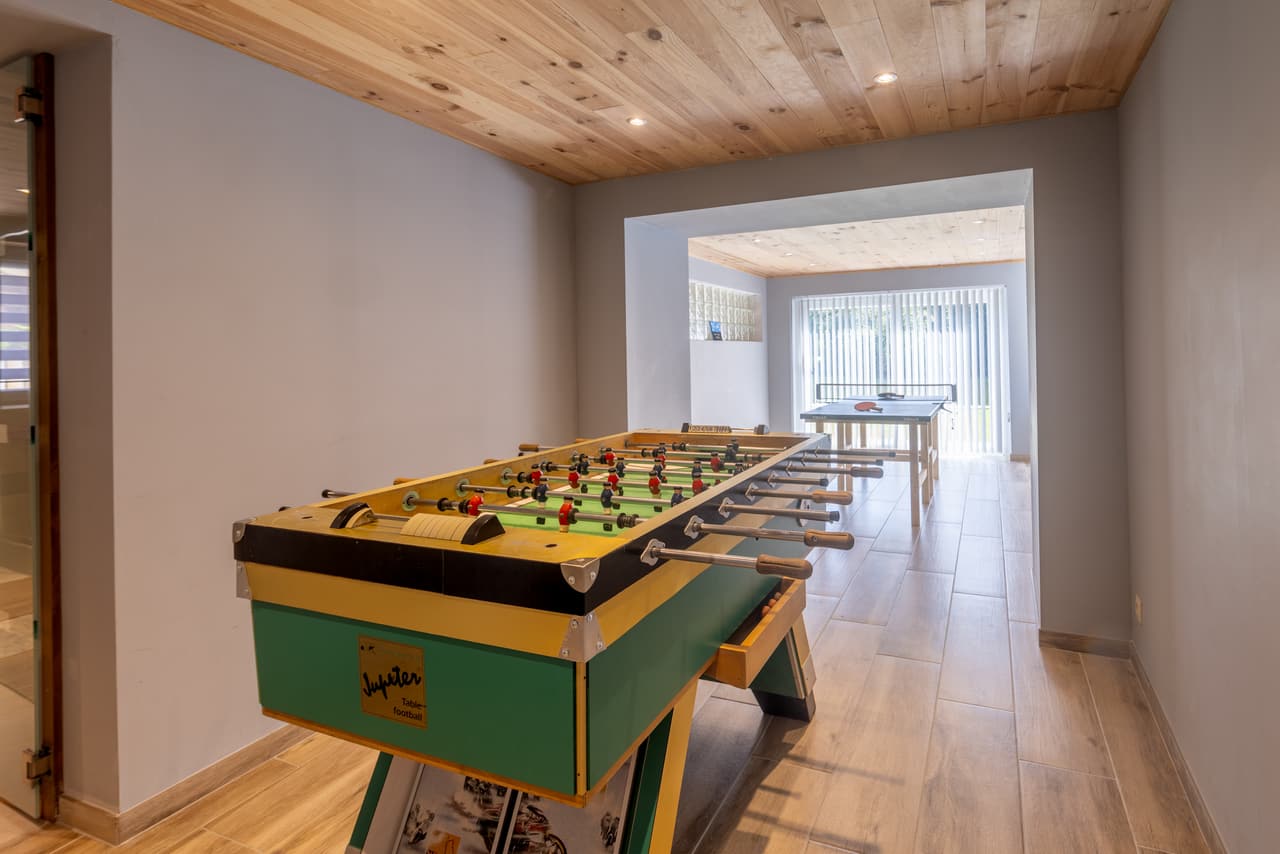 Tafelvoetbal in de speelkamer, met de pingpongtafel erachter