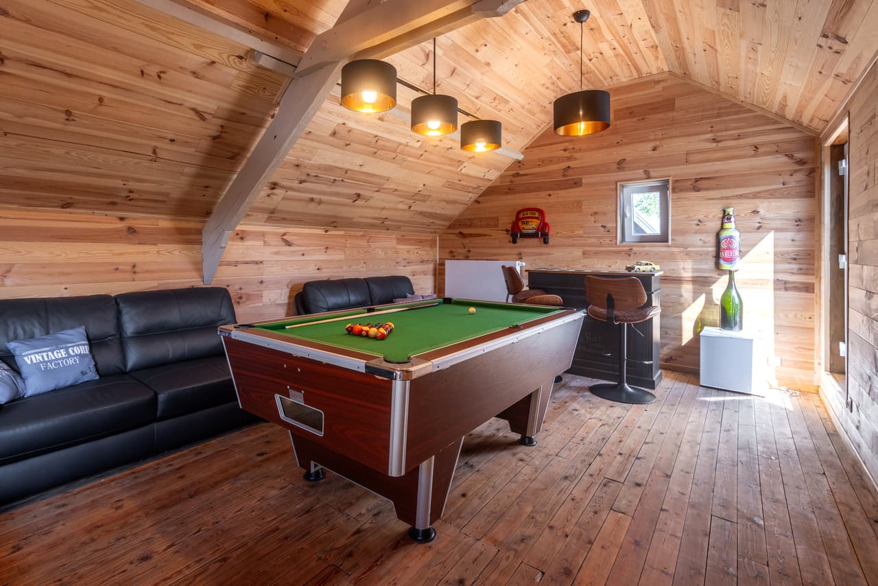 Pooltafel onder het schuine dak, met leren bank