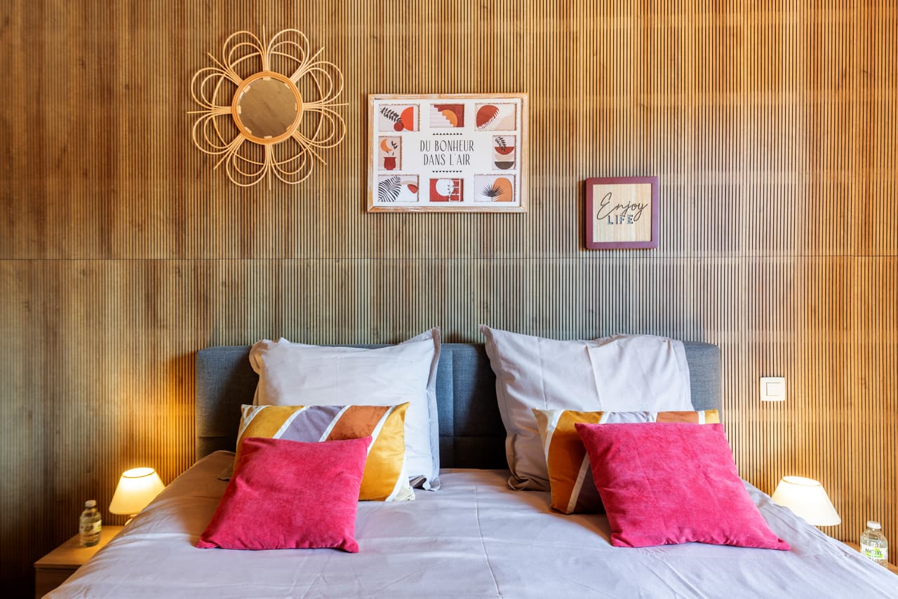 Roze kussens en houten wand in de houten slaapkamer
