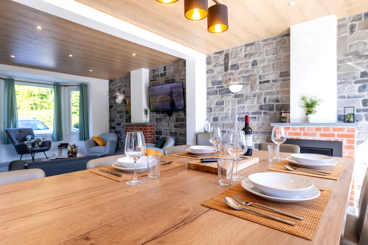 Gedekte tafel, met de woonkamer en de haard op de achtergrond