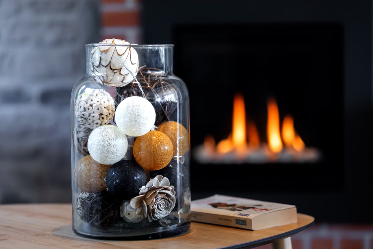 Decoratieve glazen pot op een tafel, voor de brandende haard