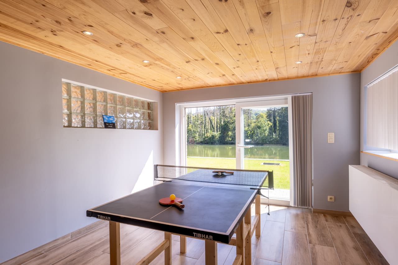 Pingpongtafel tegenover de glazen pui met uitzicht op de Maas