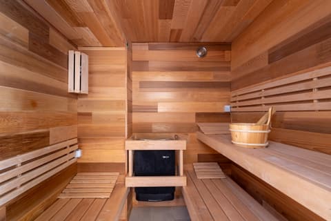Houten sauna met kachel en emmer